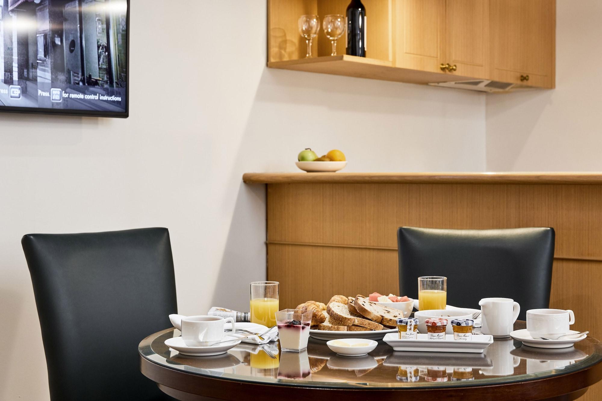 Hotel Stamford Plaza Ville de Melbourne Extérieur photo The photo shows a dining table set for breakfast or brunch. There are several food items displayed, including pastries and bread. Additionally, there are drinks, such as orange juice, served in glasses, and coffee in white cups. The table is round an
