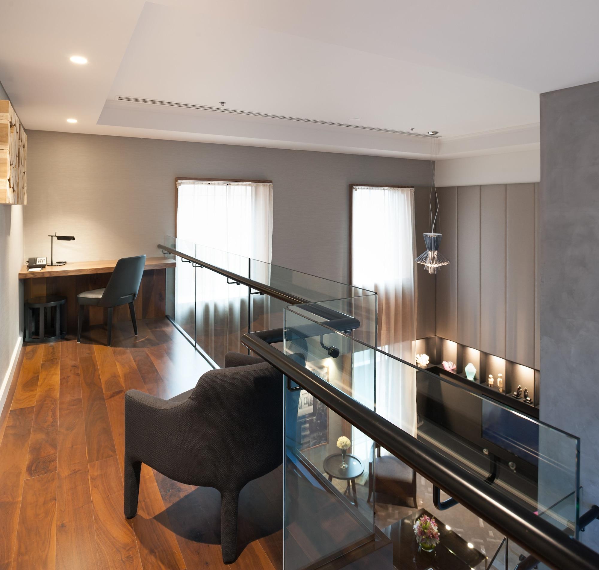 Hotel Stamford Plaza Ville de Melbourne Extérieur photo The photo shows a modern interior space, featuring a second-floor balcony overlooking a lower level. The decor is stylish and minimalistic, with a combination of wooden flooring and neutral-colored walls. 

On the upper level, there is a small desk a