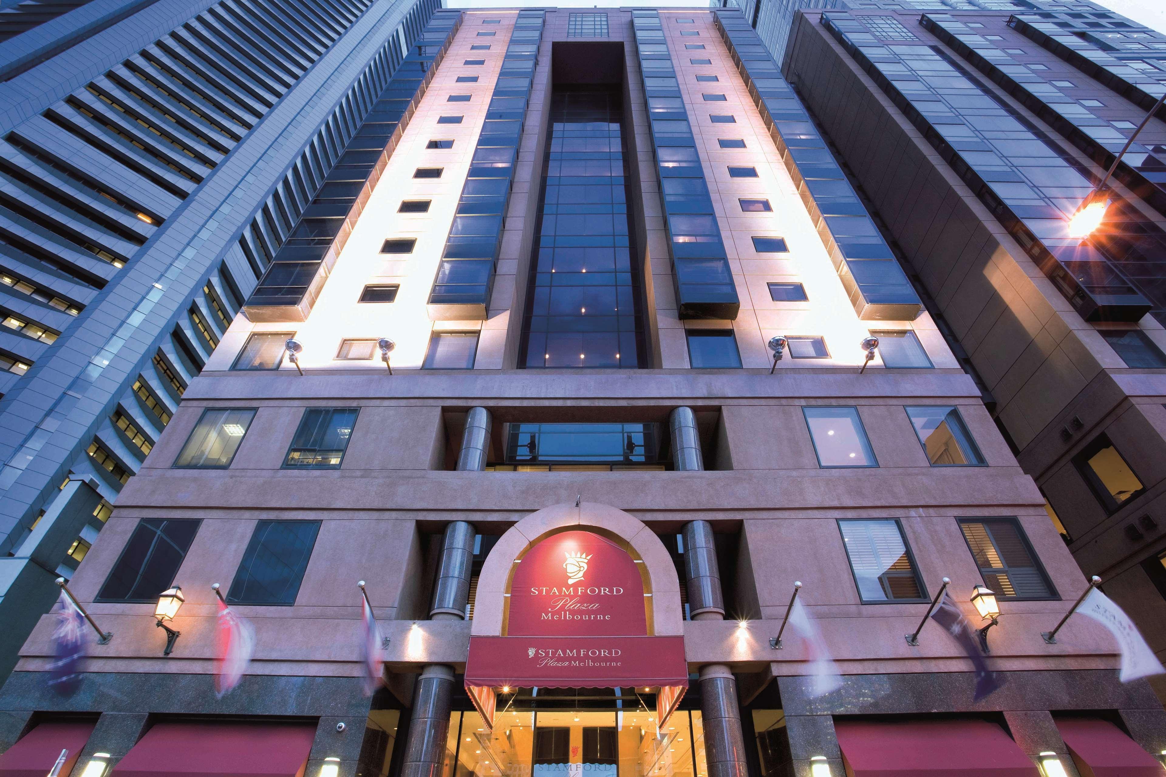 Hotel Stamford Plaza Ville de Melbourne Extérieur photo The photo shows the exterior of a modern hotel building. The structure appears tall and features a combination of glass and stone elements. Large windows are prominent, particularly in the center section, which suggests a contemporary architectural s