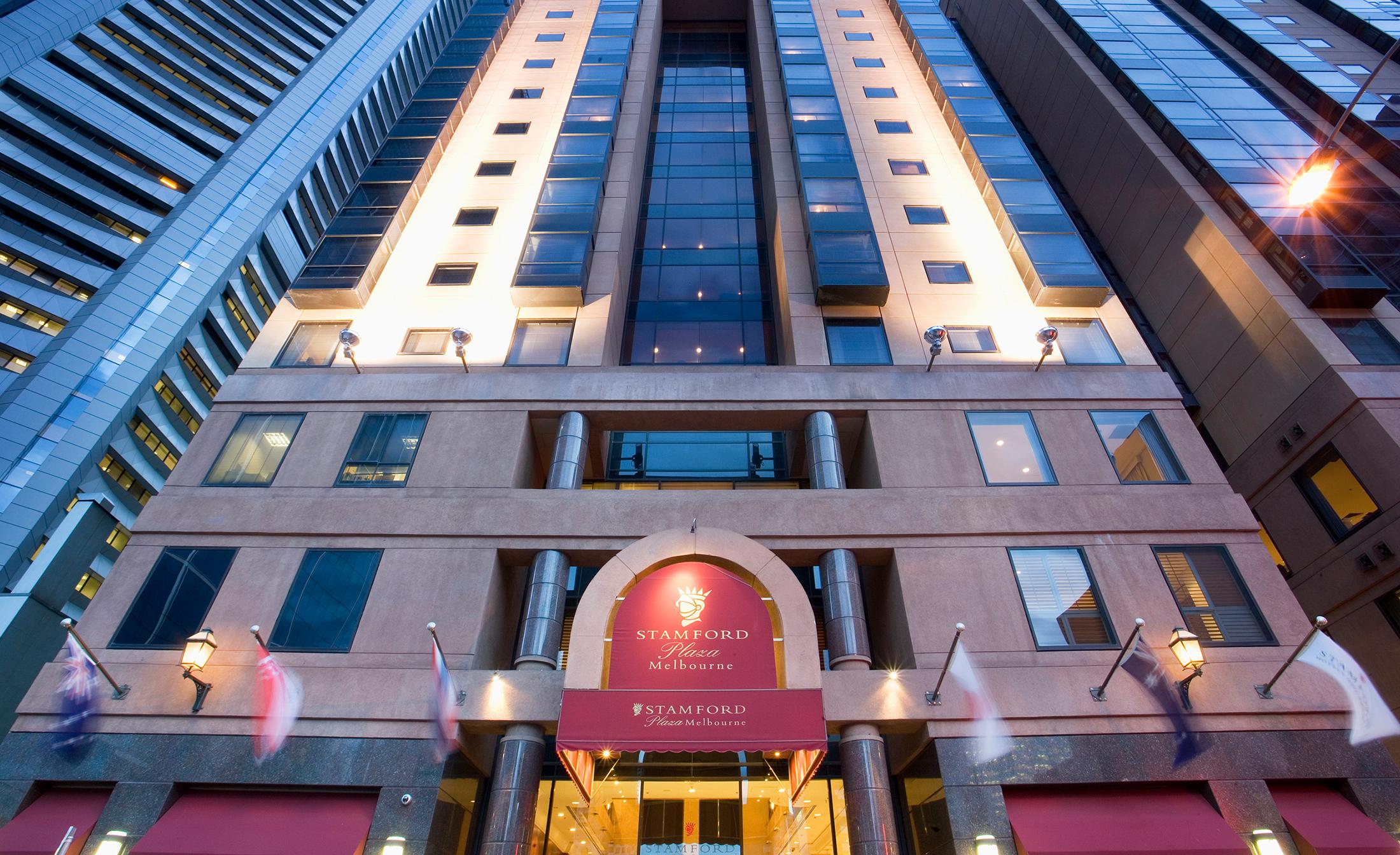Hotel Stamford Plaza Ville de Melbourne Extérieur photo The photo shows the entrance of a modern hotel building. The architecture features a tall structure with glass and stone elements. The hotel's name is visible above the entrance, which is framed by an arch, and the facade includes multiple levels wit