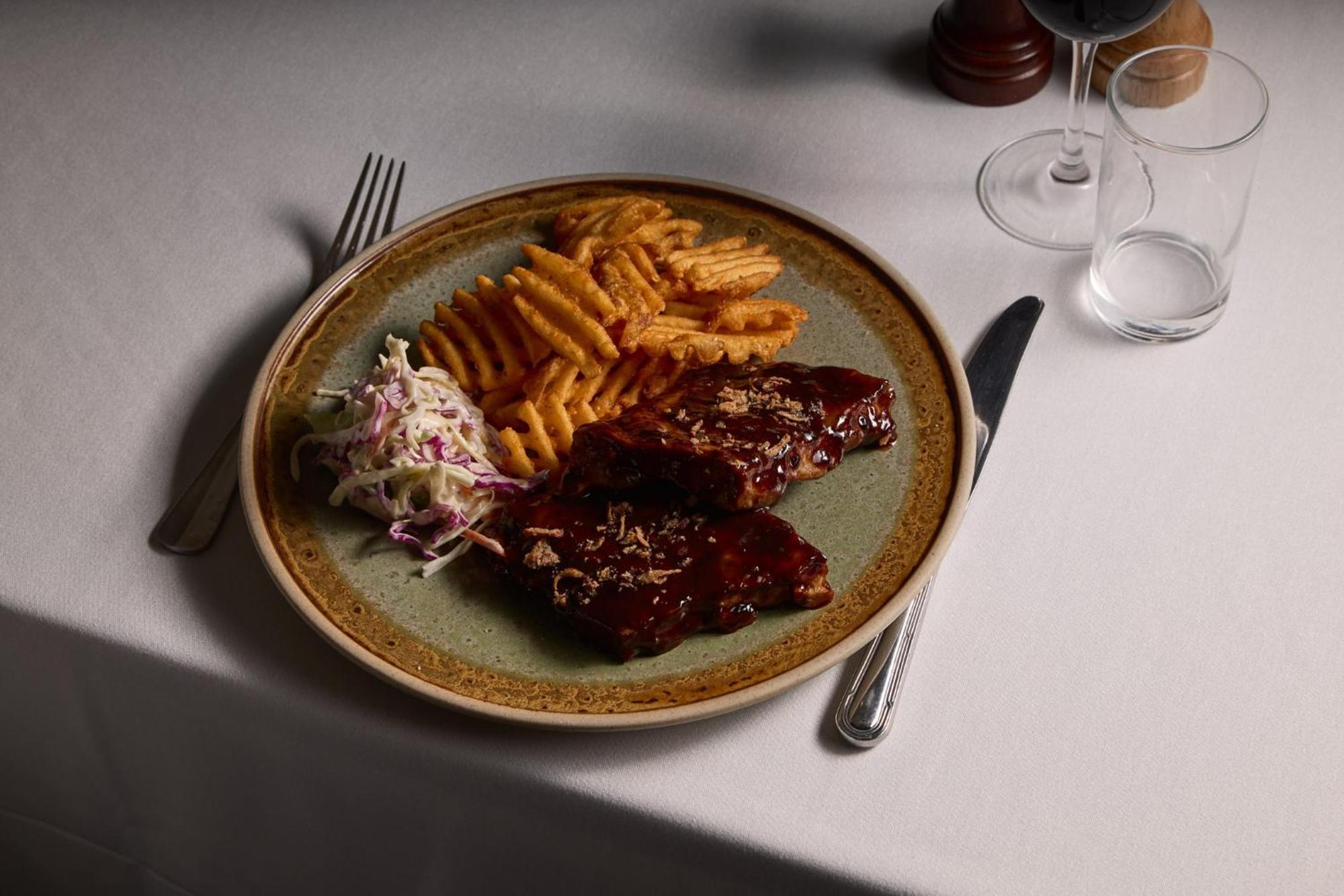 Hotel Stamford Plaza Ville de Melbourne Extérieur photo The photo displays a plate of food featuring two pieces of steak that appear to be glazed with a rich sauce. Alongside the steak, there are crinkle-cut fries arranged neatly on one side of the plate. Additionally, there's a small serving of coleslaw,