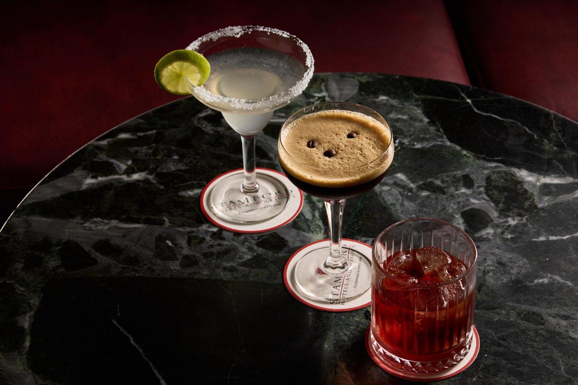 Hotel Stamford Plaza Ville de Melbourne Extérieur photo The photo features three different cocktails displayed on a dark, marble table. 

1. **Left Cocktail**: A margarita served in a traditional glass, garnished with a lime wedge and featuring a salted rim.
2. **Middle Cocktail**: An espresso martini in 