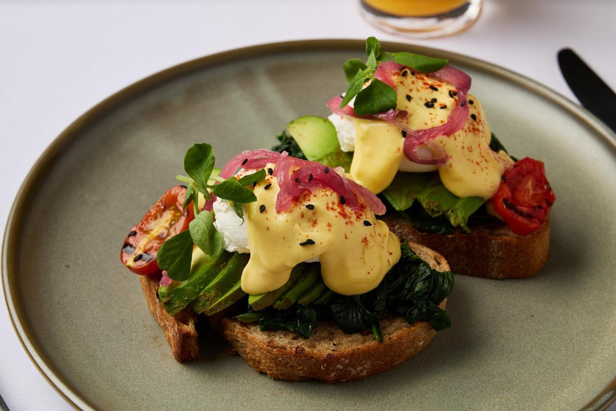 Hotel Stamford Plaza Ville de Melbourne Extérieur photo The photo shows a plate featuring two pieces of toasted bread topped with a variety of ingredients. Each slice is layered with sautéed spinach and other greens, along with slices of cucumber and cherry tomatoes. The dish is finished with poached eggs