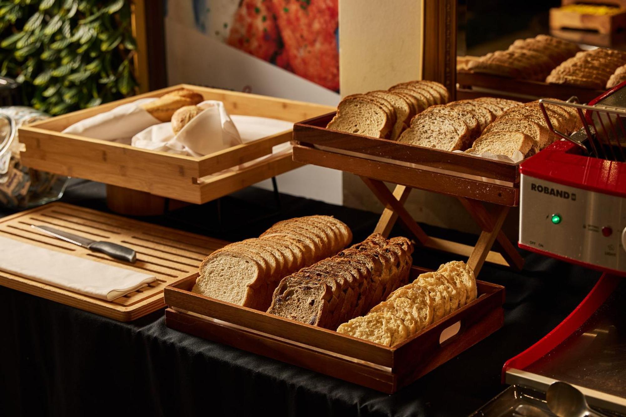 Hotel Stamford Plaza Ville de Melbourne Extérieur photo The photo shows a display of various types of bread arranged on wooden trays. There are several stacks of sliced bread, including light and dark varieties. One tray appears to hold a selection of whole grain or multigrain bread, while another feature